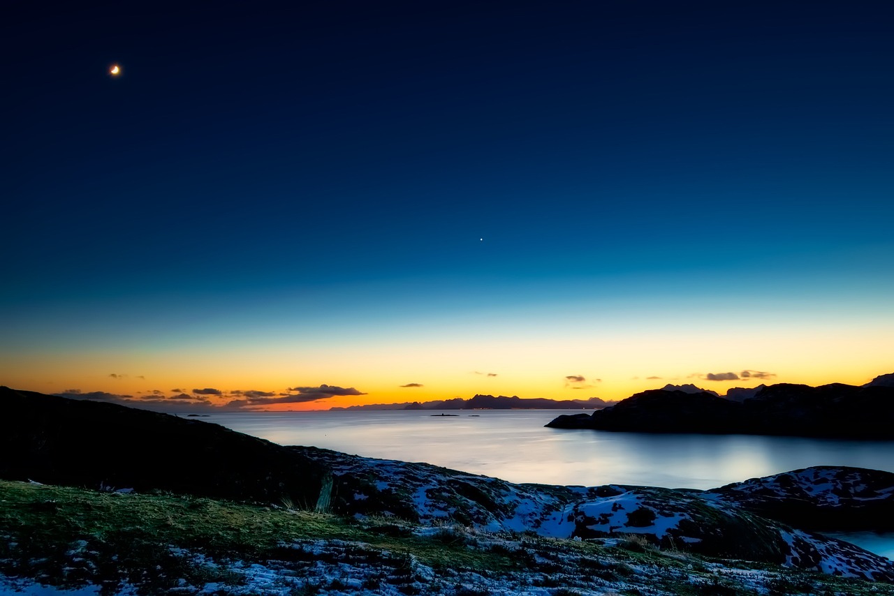 Abendstimmung mit einem rötlich-orangen Horizont an einem See.